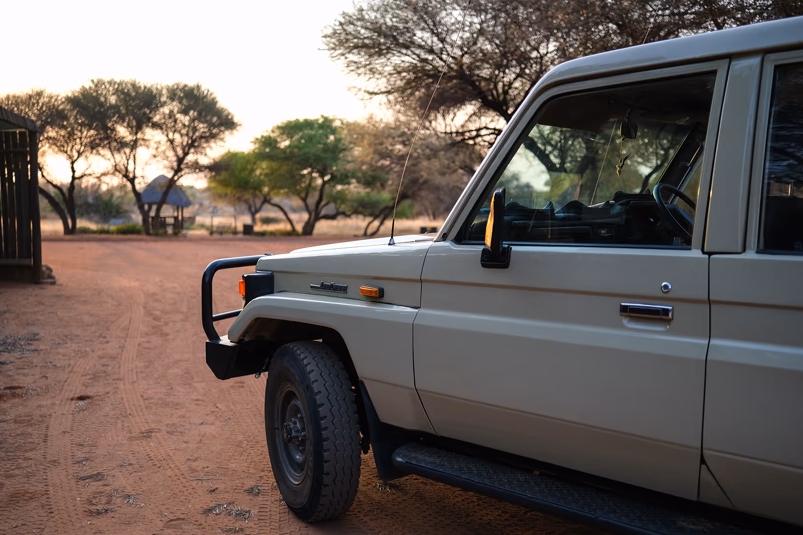 A Cruiser Safaris hunting vehicle parked at camp at sunrise